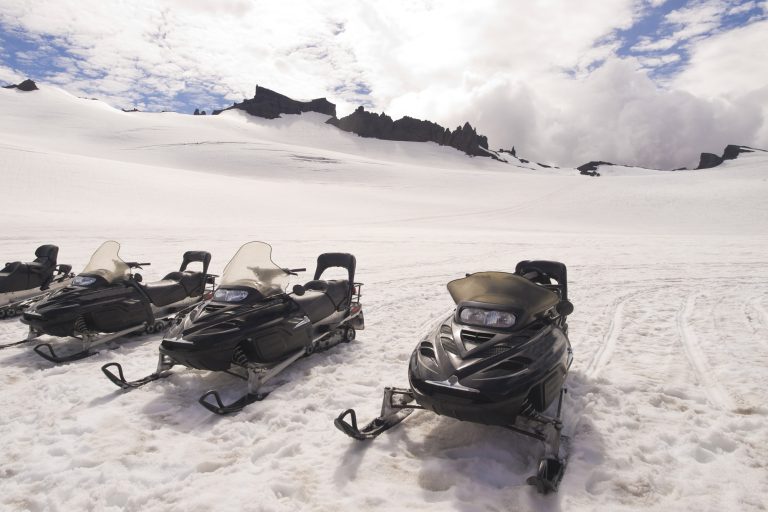 south iceland snowmobiles awaiting drivers on glacier istk