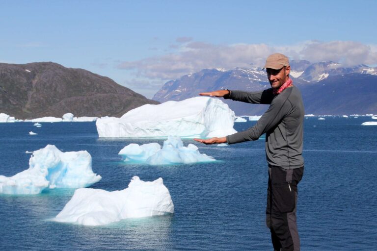 south greenland icebergs in fjord with hiker taser