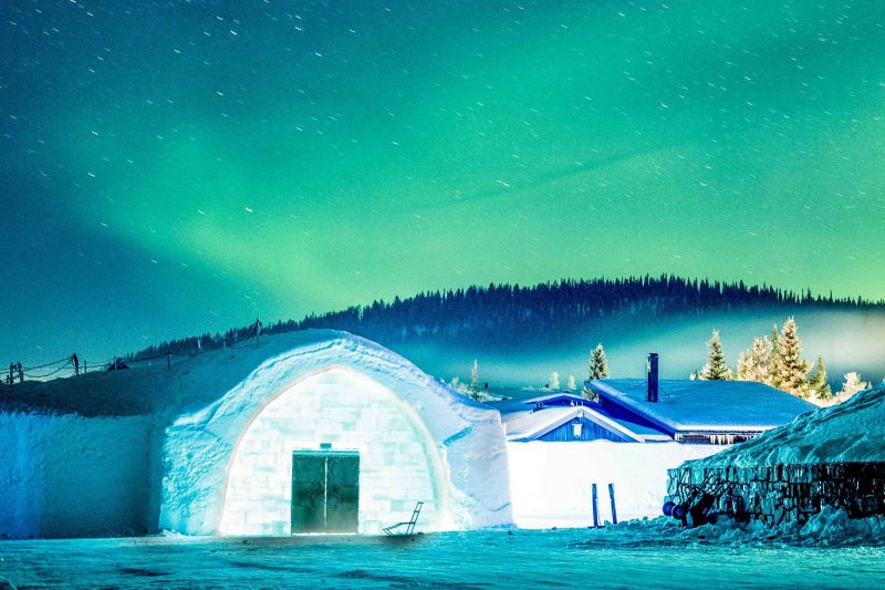 swedish lapland icehotel entrance with aurora overhead ak