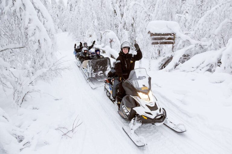 finnish lapland ranua snowmobiling with children on sled