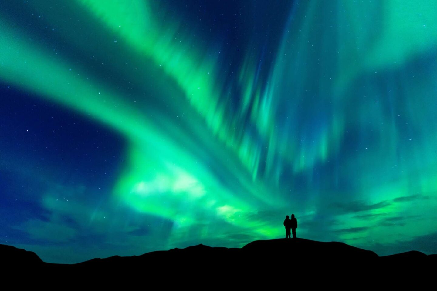swedish lapland couple watching aurora borealis istk