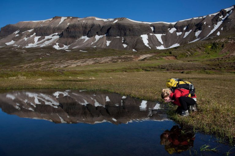 iceland east fjords hiker drinking from river istk