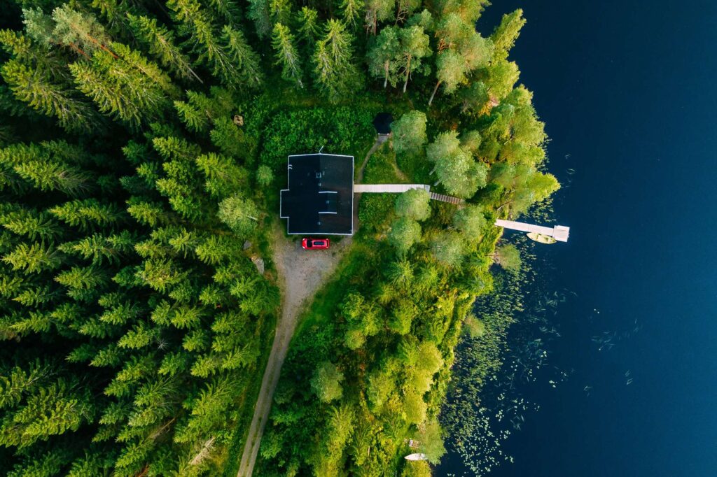 finland aerial view over pine trees and lake house istk