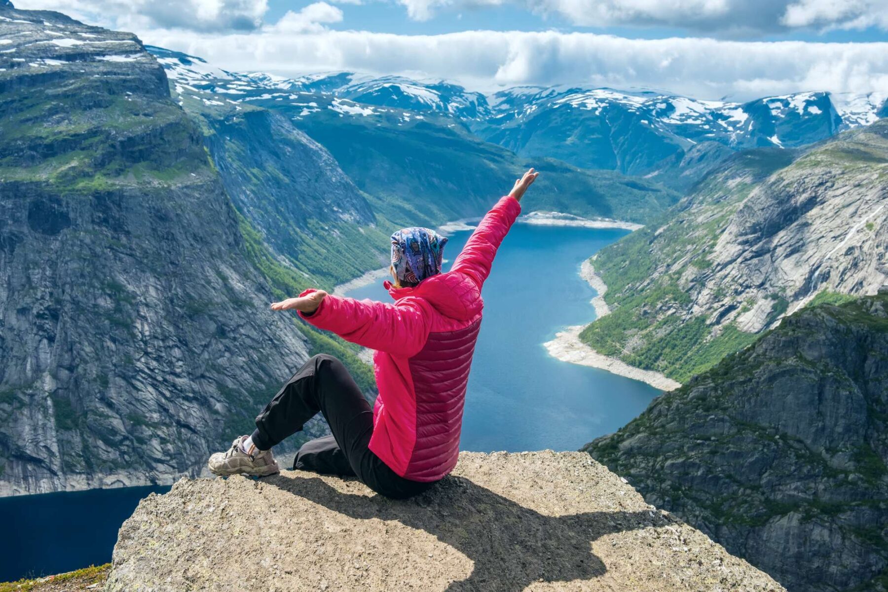 fjord norway woman sitting on edge of trolltunga istk