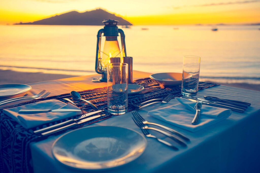 pacific islands beachside dining at sunset istk
