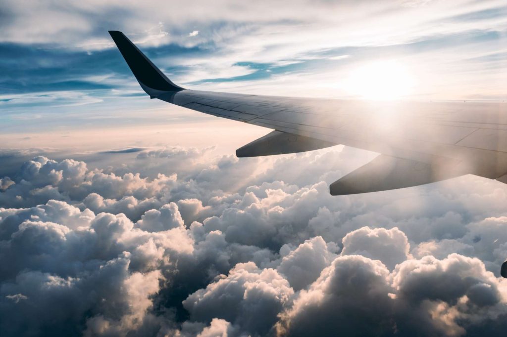 aircraft wing through clouds by jerry zhang unsplash