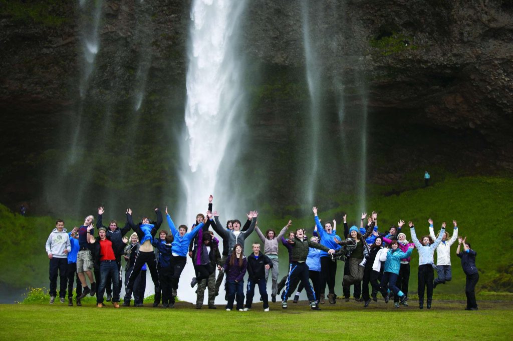 iceland students jumping waterfall