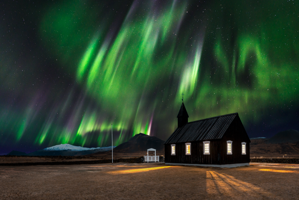 Picture of the northern lights behind Vik church in Iceland
