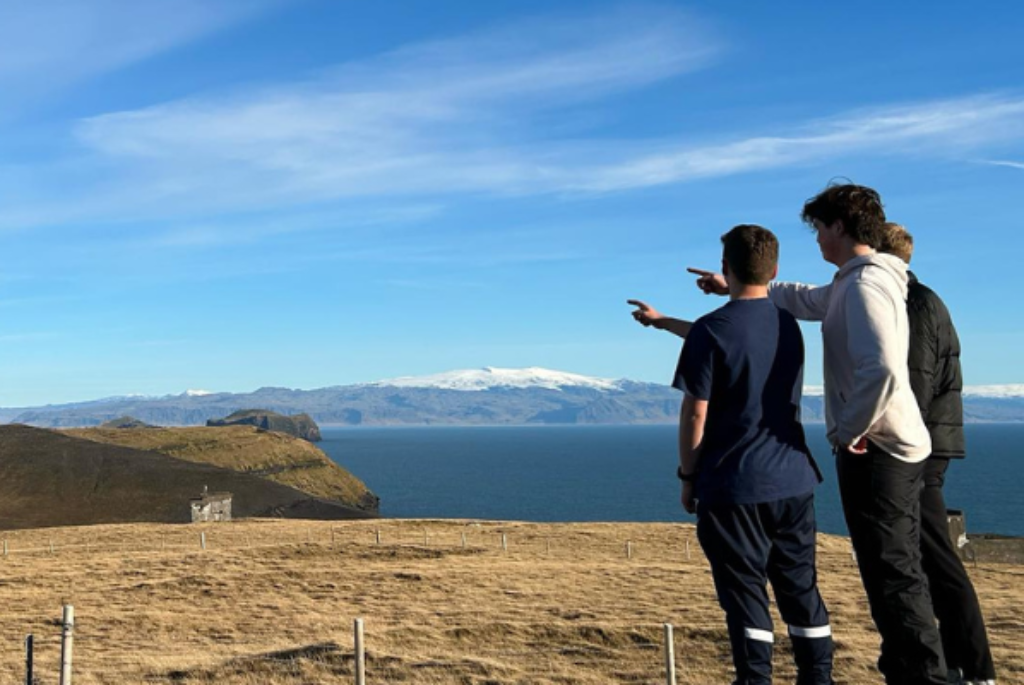 Picture of students pointing to a cliff in the distance